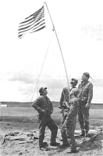 Deputies raising American flag after the AIM led occupation at Wounded Knee
