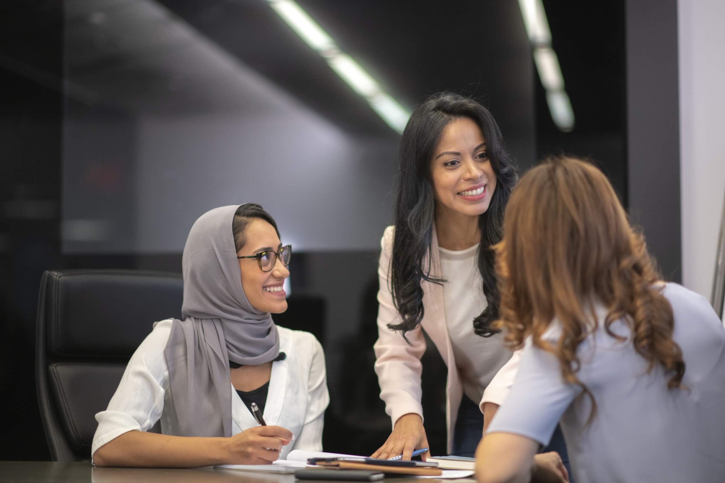 Three young girls chatting - one is wearing Hijab