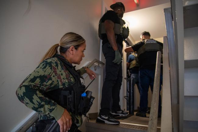 Deputy U.S. Marshals Female outside of a residence during…