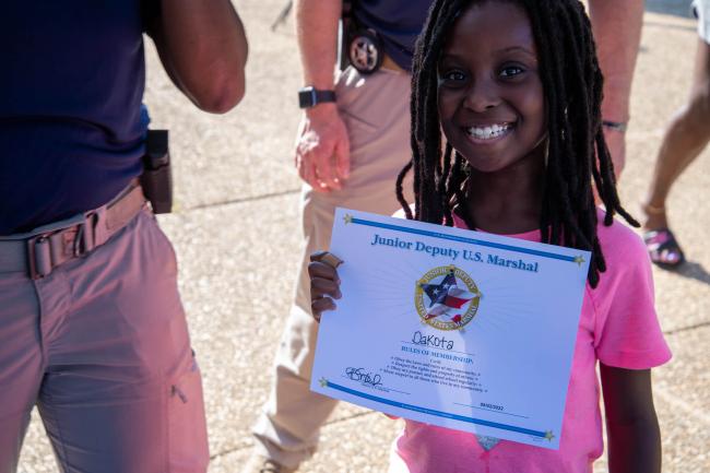 Child holding up a Junior Deputy Certificate during the…