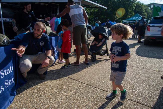 Deputy U.S. Marshal talking to a young child during the…